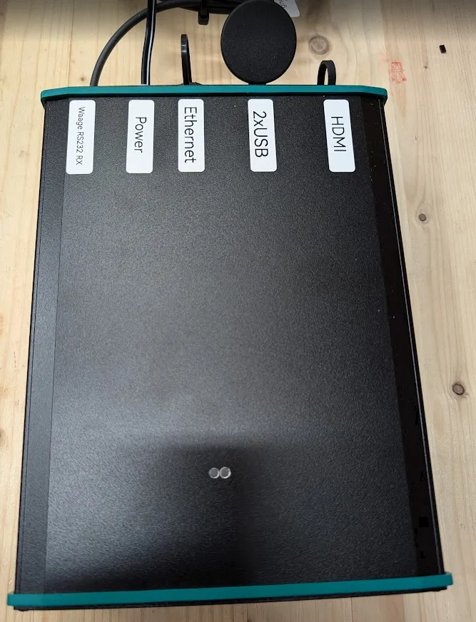 Blick von oben auf das Aluminium-Tischgehäuse des Weightcontrollers mit der Beschriftung der Anschlüsse an der Stirnseite